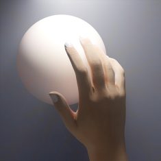 An artwork with a human hand touching a magical sphere